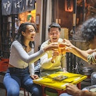 Young Japanese and mixed race friends in 20s laughing and toasting good news outdoors at Tokyo izakaya.
1227451731