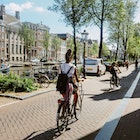 Woman cycling in Amsterdam, commuting or just sightseeing on a bright summer day.
1416056985