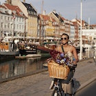 Happy young woman with sunglasses enjoying while riding bicycle on Nyhavn pier in city
1692796054