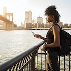 769732881
mobile phone, standing, bridge, River, woman, communication, phone, water, people, Adults, curly, backpack, summer, relaxed, black, leisure, urban, on the move, Connection, View, Travel, skyscraper, sky, sunlight, sunset, outdoors, side view, Backlit, day, Skyline, technology, urban scene, casual, three-quarter length, promenade, Afro, copy space, relaxation, accessibility, lifestyle, journey, wireless, Railing, riverside, top, Brooklyn Bridge, City Break, East River, Looking At View, Lens Flare, Waterfront, Traveller, cityscape, Smartphone, female tourist, single traveler, mid adult woman, one person, 30-34 years, African descent, African-American Ethnicity, female Afro-American, Brooklyn, colour, city, built structure, building, high-rise, sunshine, atmosphere, city view, waters edge, tourism, looking, tourist, mid adults, 30-40 years, USA, New York State, New York City, Photography, Color Image
A woman standing on the waterfront of the Hudson River with the Manhattan skyline in the background