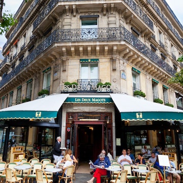 Paris, France - June 27, 2012: Cafe Les Deux Magots. Les Deux Magots is a famous caf!AA> in the Saint-Germain-des-Pr!AA>s area of Paris. It once had a reputation as the rendezvous of the literary and intellectual !AA>lite of the city. It is now a popular tourist destination. Parisians and tourists are enjoying a beautiful summer day outside.
458231415
Capital Cities, Paris Left Bank, Residential Structure, Building Exterior, Awning, Color Image, Entrance, Eating, Sidewalk, History, Green, Architecture, Urban Scene, Outdoors, Vertical, People, St-Germain-des-Pres, Latin Quarter, Paris - France, France, Europe, Day, Summer, Sky, Balcony, House, Cafe, Restaurant, Street, Built Structure, Cafe des Deux Magots