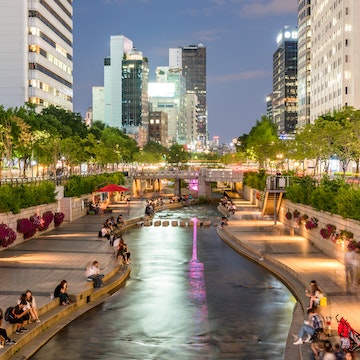 People relaxing by Cheong-Gyecheon stream in the centre of Seoul on a summer evening