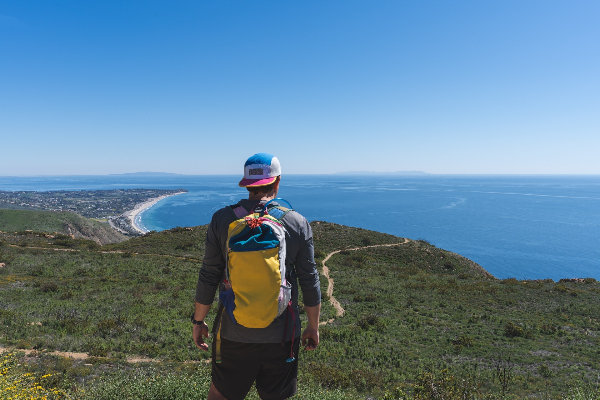 A hiker looking out at the Pacific Ocean from a summit Charmlee Wilderness Park, Malibu, California, USA