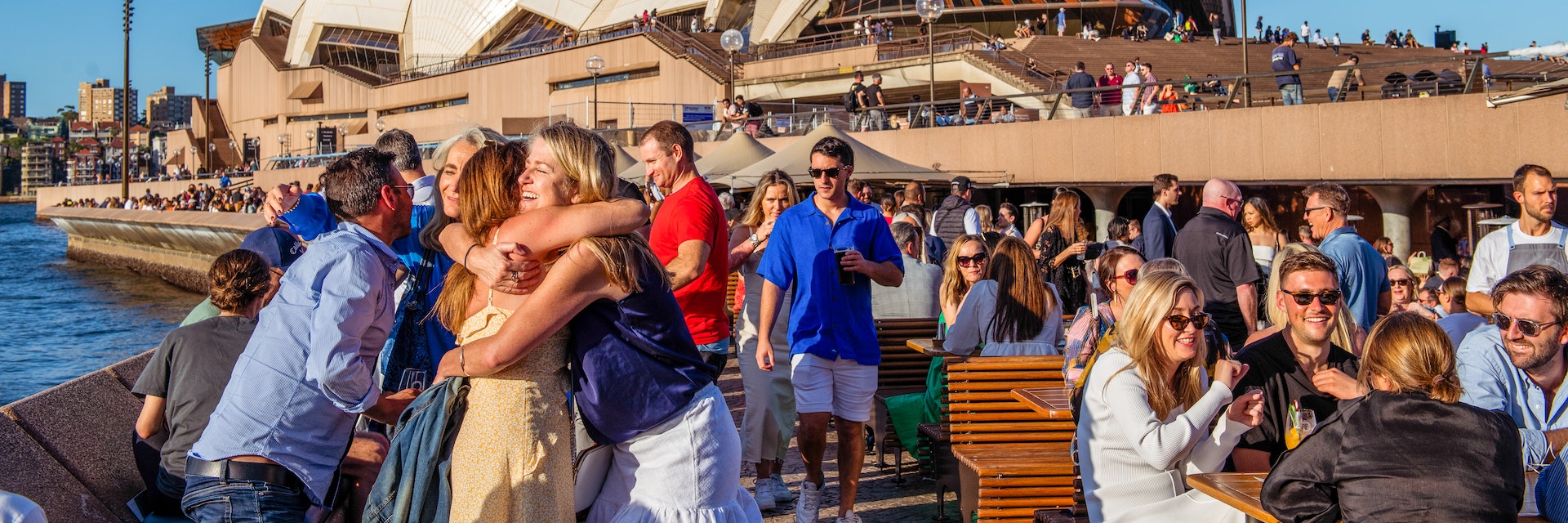 Friends hug in front of the Sydney Opera House © Isabella Moore/Lonely Planet